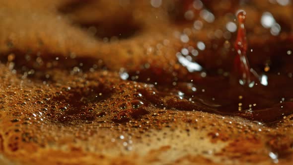 Super Slow Motion Macro Shot of Splashing Fresh Coffee and Water Droplets at 1000 Fps