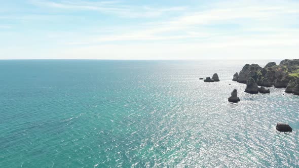 Atlantic Ocean and rocky Algarve coastline on sunny breezy day. Aerial South of Portugal