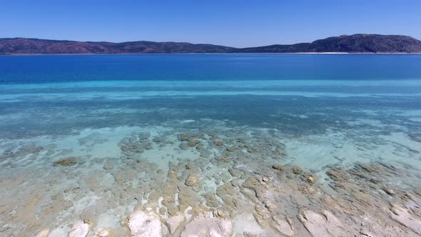 White Sandy Coral Reef in the Clear Turquoise Light Blue Sea of the Tropical Coastline