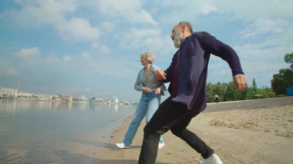 Seniors Having Fun Throwing Pebbles Into Water at River or Lake Bank
