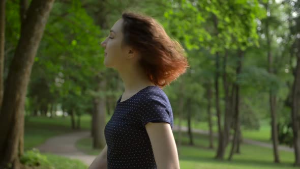 Portrait of a Young Beautiful Girl, Unfolding Into the Camera in the Park