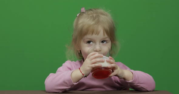 Girl Sitting at the Table and Drinks Yogurt Milk. Funny Milk Mustache