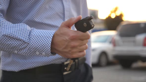 Young Business Man Walking at Parking Outdoor and Holding at Hand Key of Car