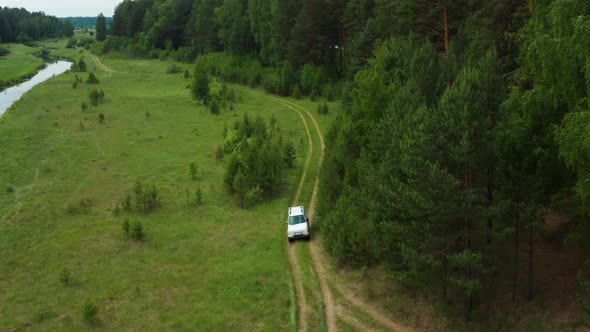Aerial View of a Car Driving Along the River Bank