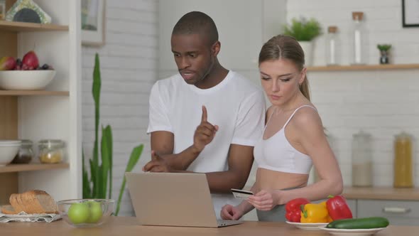 Athletic Woman and African Man Making Online Payment on Laptop