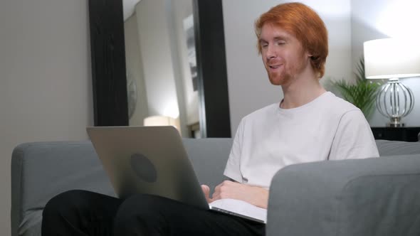 Online Video Chat on Laptop by Casual Redhead Man