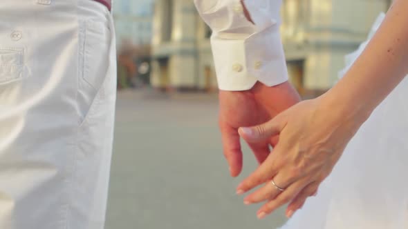 The Newlyweds Tenderly Holding Hands.