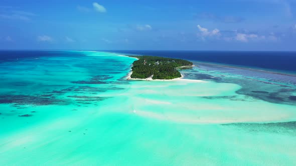 Wide angle birds eye island view of a paradise sunny white sand beach and aqua turquoise water