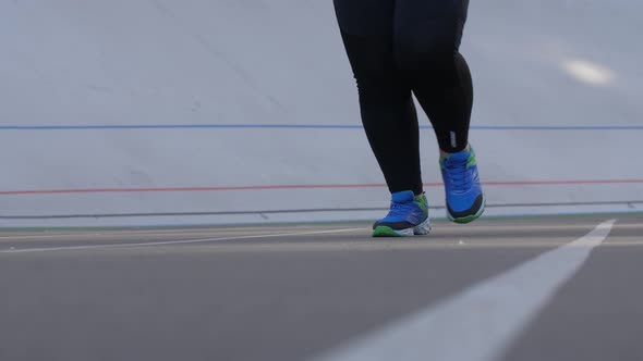 Legs of Overweight Woman Running on Sports Stadium