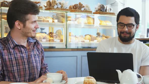 Young People Chatting Over Cup of Coffee at the Cafe 