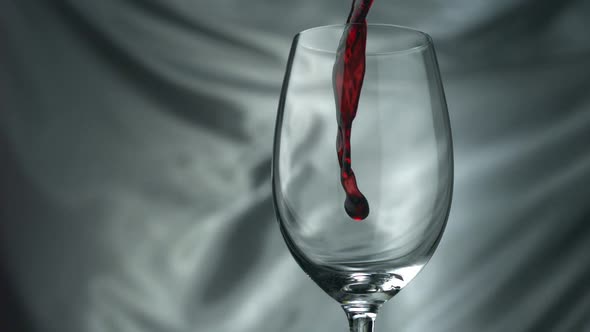 Pouring red wine into glass, Slow Motion