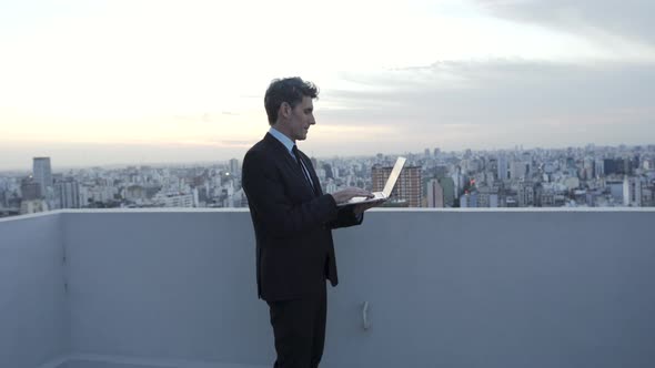 Businessman working on laptop outdoors