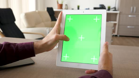 Tablet PC in Vertical Position with Green Screen Chroma Mockup Beeing Hold By Male Hands