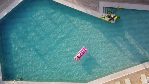 Young Pretty Woman on Air Mattress in the Pool