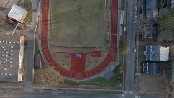 Aerial ascending over soccer field and track in Durham, North Carolina, United States. Overhead view