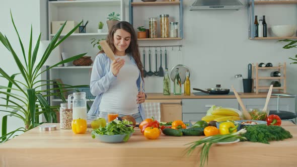 Happy Pregnant Woman Dancing in the Kitchen in the Morning