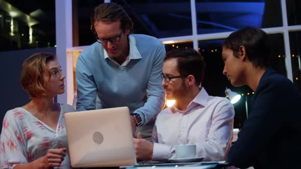 Businesspeople having discussion over laptop