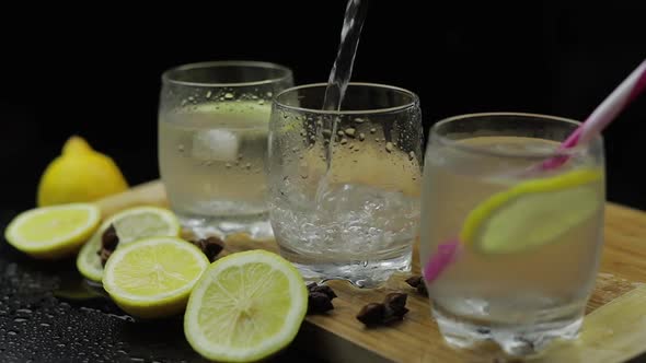 Pour Lemon Juice Into Glass with Ice and Lemon Slices. Lemon Alcoholic Cocktail