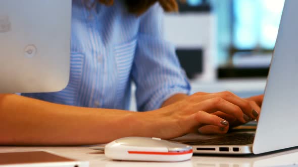 Business executive using laptop at desk