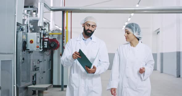 Young Engineer and Baker Woman in a Big Bakery