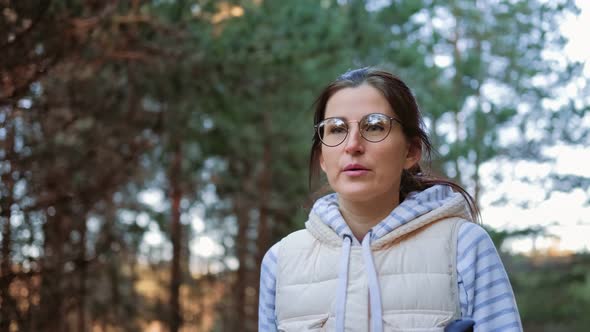 Sportswoman Going with Trekking Poles at Forest