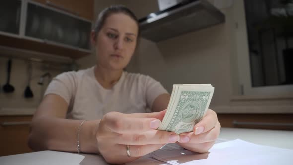Closeup of Poor Woman with Financial Problems Counting Money and Holding Head