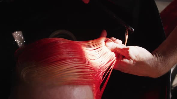 Close up view hairdresser brushing woman hair