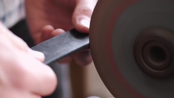 The Craftsman Is Sharpening the Edges of a Belt on a Special Machine