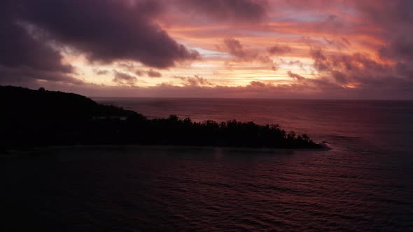 The fiery red sunset colors over the mountain island of Fiji - aerial