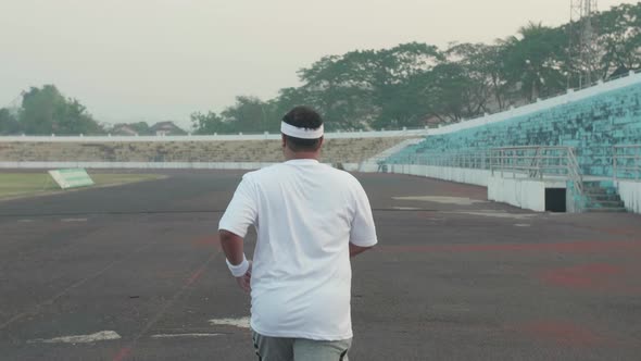 Asian Fat Man Jogging At Stadium