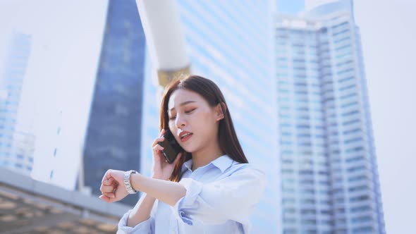 Woman Talking on Phone and Checking Watch