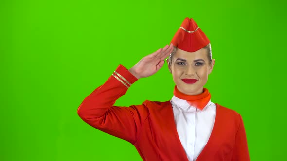 Stewardess in a Red Suit Salutes the Pilot. Green Screen