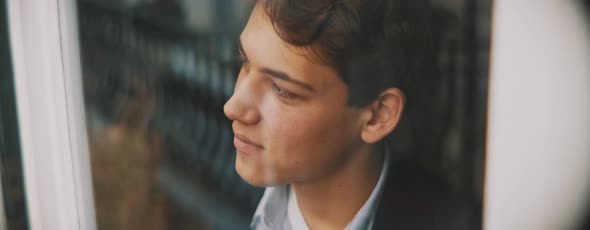Young european man looking around from the window, smiling
