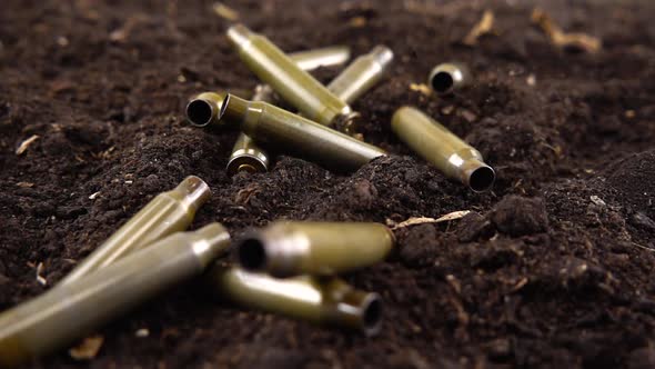 Bullet casings fall to the ground. Slow motion. alt