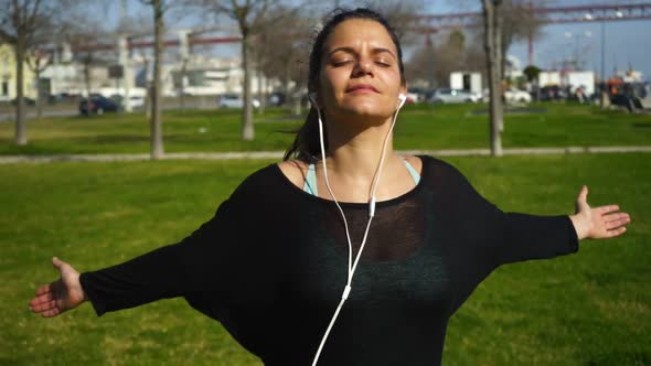 Brunette Girl with Closed Eyes Exercising in Park