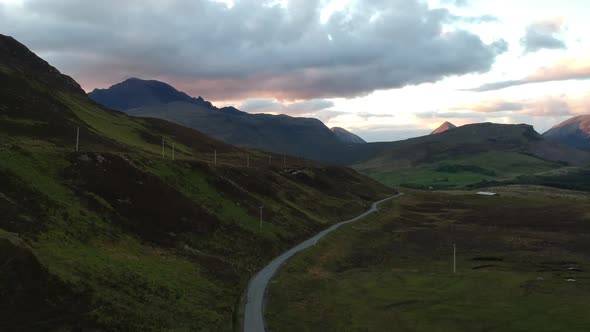 Panning drone shot of Scottish winding road with mountains. Aerial video shot by in Scotland highlan