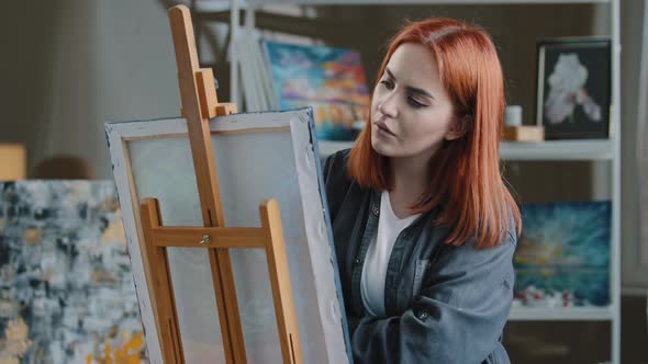 Portrait Pensive Redhaired Caucasian Woman Paints in Room Thinking About Idea Create Picture Ponder