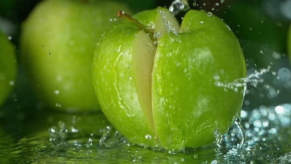 Super Slow Motion Shot of Falling Fresh Cutted Apple with Water Splashing at 1000Fps