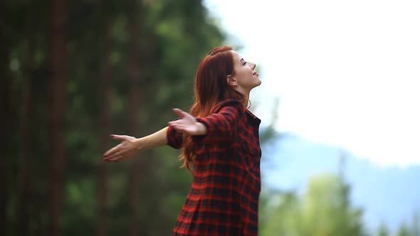 Redhead girl feel free in a forest