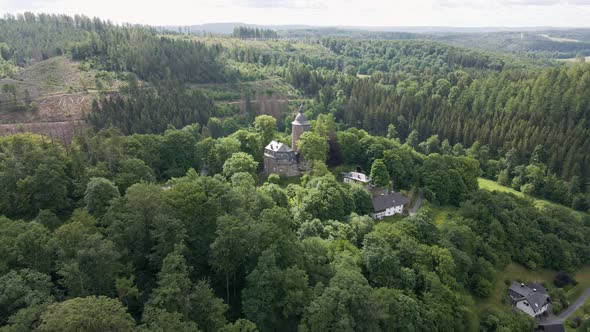 rearward drone shot of Wildenburg Castle in the southeast of the village of Friesenhagen in the Nort