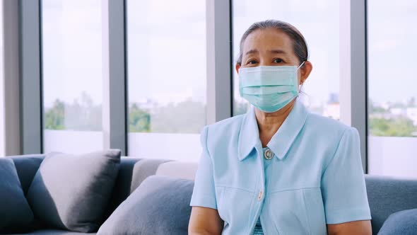 Senior woman wearing protective face masks during quarantine at home.