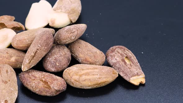 Rotating close up shots of a bunch of fried, natural almonds with skin and salt. Macro shot, 4k, bla