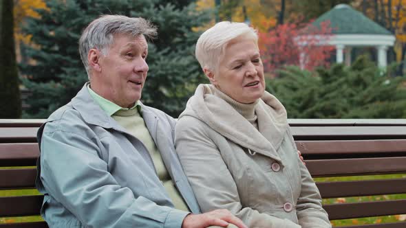 Caucasian Elderly Family Rest Time Together in Autumn Park Sit on Bench Married Couple Partners