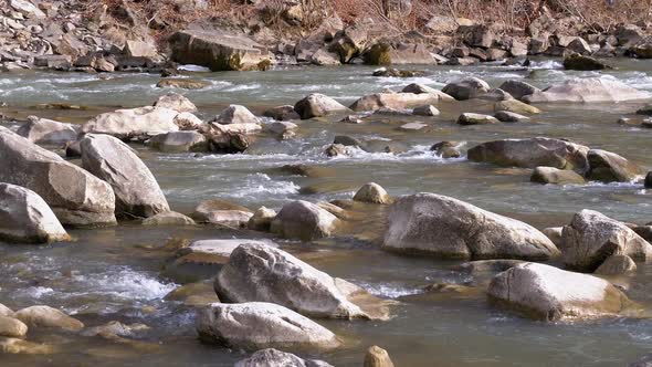 Wild Mountain River Flowing with Stone Boulders and Stone Rapids. Slow Motion