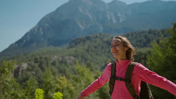 Happy Joyful Woman Tourist Enjoys Breathing Fresh Air in Mountains at Sunny Day