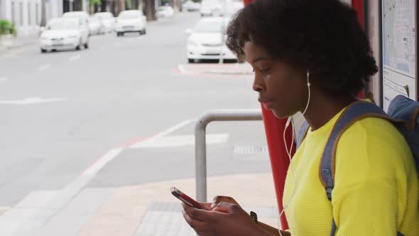 African american using her smartphone in street