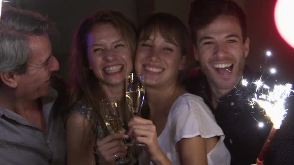 Friends celebrating at night with champagne and sparklers