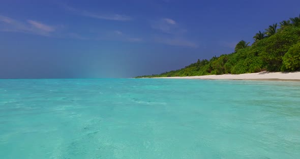 Daytime fly over clean view of a sunshine white sandy paradise beach and blue sea background in best