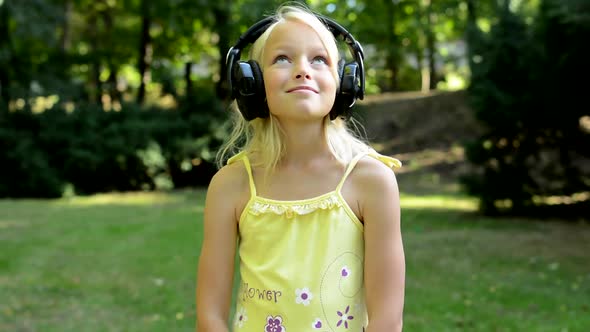 Little Cute Girl Listen Music in the Park - Big Gamer's Headphone