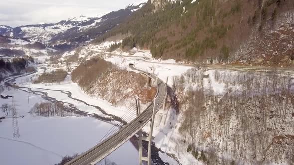 Cars on a very high bridge in Switzerland. Drone flies over it and turns around.